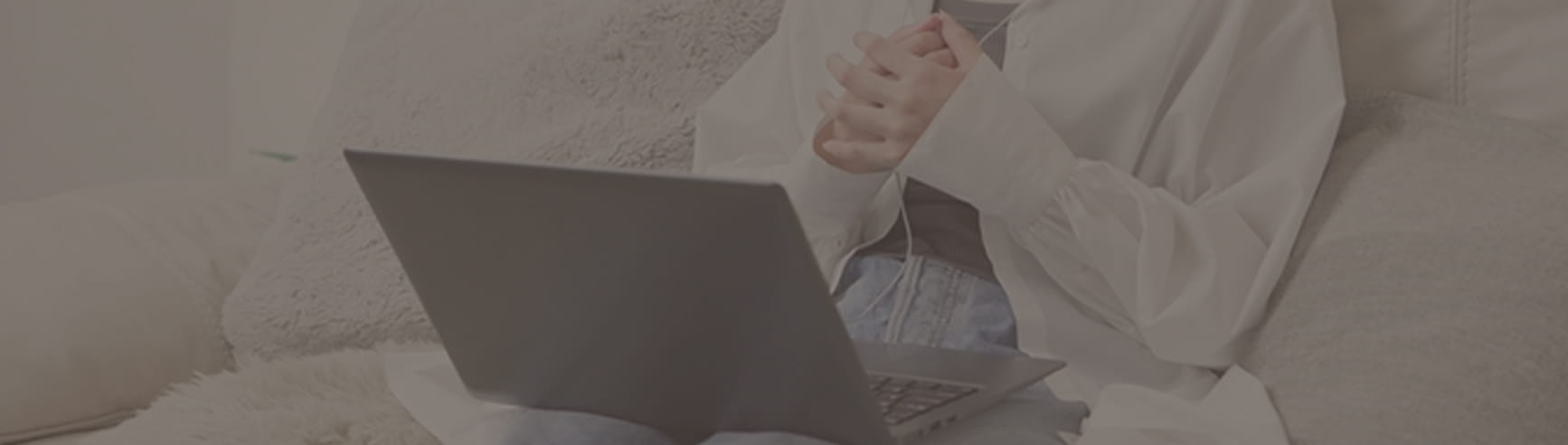 ソファに座ってパソコンで相談している女性