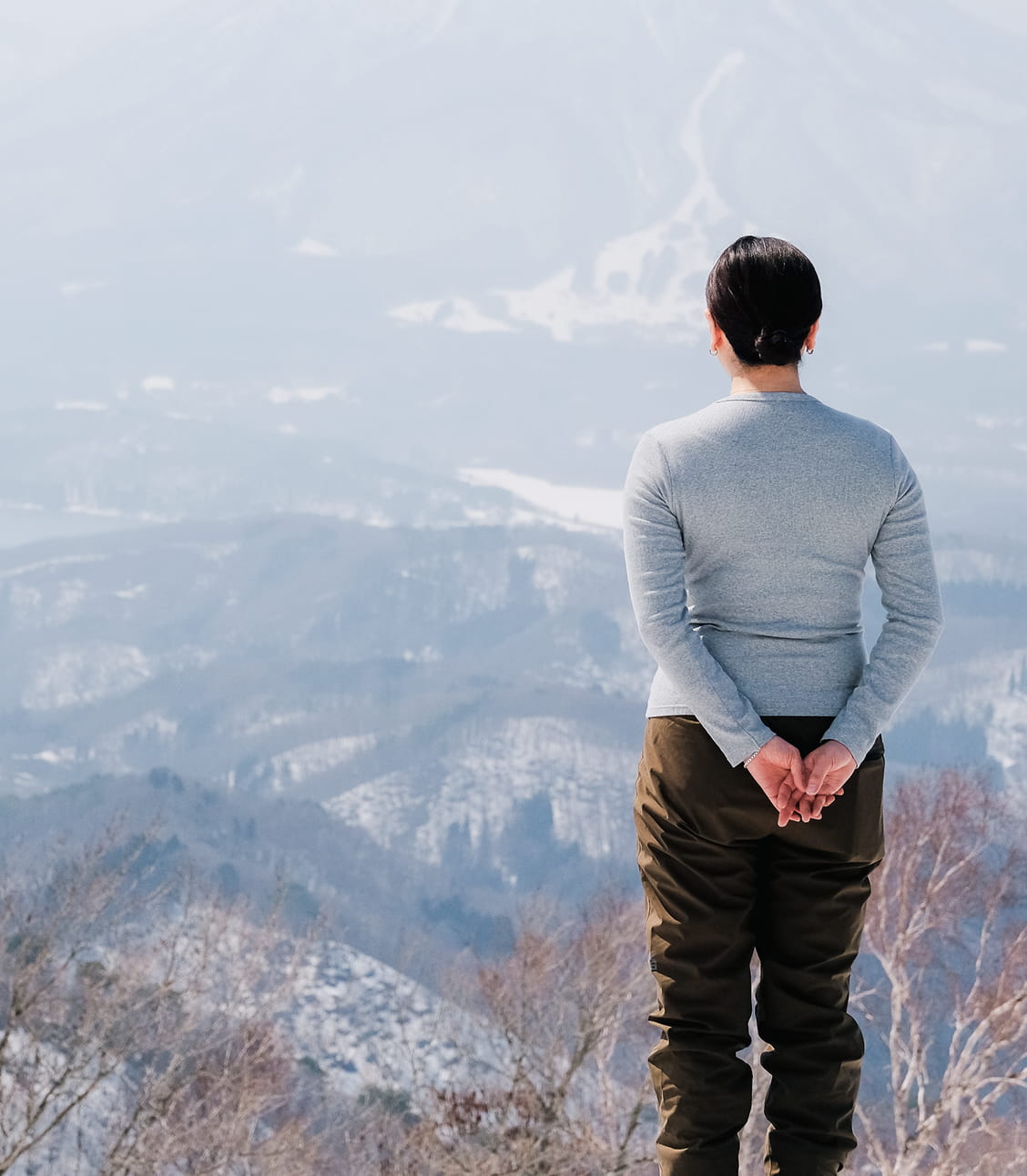信濃町の雪景色を眺める女性の後ろ姿