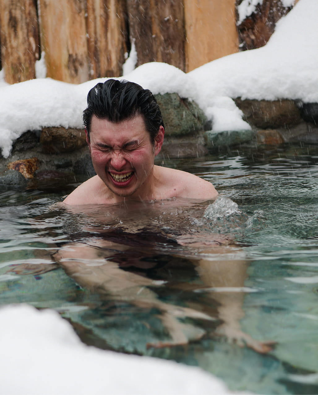 サウナの雪が積もった水風呂を楽しんでいる人
