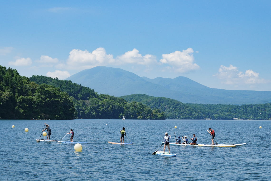 カヤックで人々が遊ぶ夏の野尻湖の風景